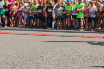 Children marathon runners crowd, young teen sportsmen participants start running in the city streets, crowd of kids joggers in motion, kid group athletes outdoor run, family competition in summer day