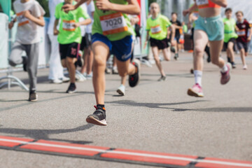Children marathon runners crowd, young teen sportsmen participants start running in the city...