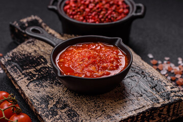 Delicious hot spicy red sauce with salt and spices in a ceramic bowl
