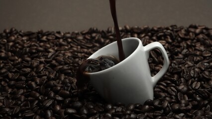 Fresh espresso was poured in white cup with pile of coffee bean. Pouring black coffee in the cup with brown background and seed scattering around on wooden table. Close up. Slow motion. Comestible.