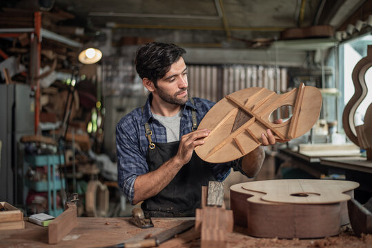 Luthier creating a guitar and using tools in a traditional
