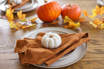 Autumn, fall, Halloween or thanksgiving festive day table setting with yellow leaves and pumpkins