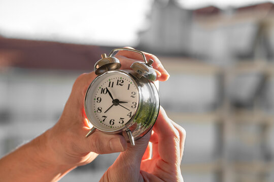 hands adjusting or changing the time on clock