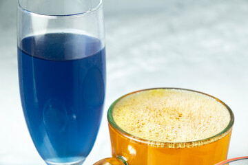 top view of a glass of champagne with blue water and a glass of yellow beer isolated