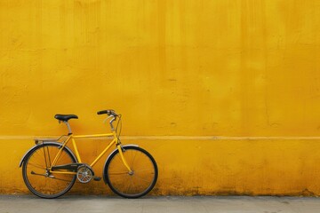 Naklejka premium A bright yellow bike leans against a yellow wall in a cheerful outdoor setting