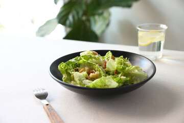 Caesar salad with croutons and parmesan cheese in black dish on white background italian food, italian culture