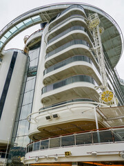 High back of a large cruise ship with balconies on a sky background, ship hull washing facility