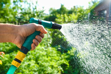 man watering splashing garden in park outdoors background