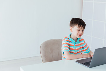 Schoolboy At Table With Laptop Online Learning