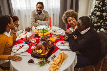 African American family having Thanksgiving, Christmas dinner. Delicious food is being served.