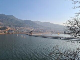 Scenic view of traditional pavilion and bridge over calm lake in the mountains