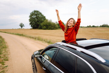 Happy woman resting and enjoying travel out of the car window. Car Adventure. Travel, tourism, nature, active life