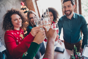 Photo of nice young people team employees drink champagne enjoy cozy christmas decoration interior office indoors corporate party