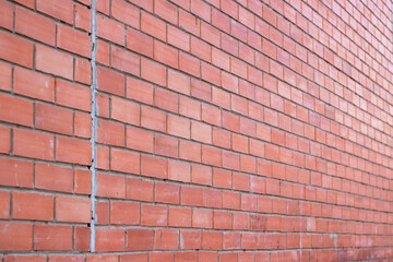 A detailed close up of a red brick wall covered in fresh snow on it