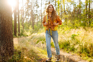 Young woman went on a hike in the forest feeling free and full of energy. Autumn landscape.