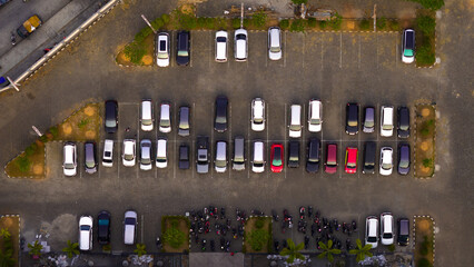 Bird's eye view of an orderly urban parking lot filled with cars, showcasing everyday organization and city life