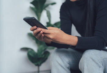 Casual Smartphone Use: Close-up of hands holding a smartphone, conveying a sense of relaxed digital engagement.  The image is perfect for illustrating casual mobile usage in a modern setting. 