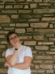 Thoughtful woman pondering against a textured stone wall background
