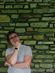 Thoughtful woman pondering against a textured stone wall background