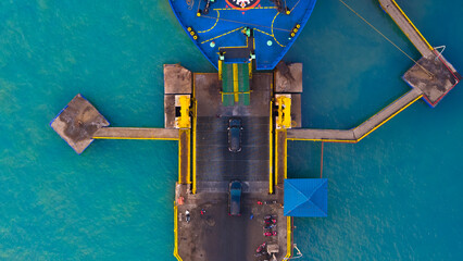 Aerial view showcasing the vibrant contrast between industrial pier infrastructure and the serene blue waters