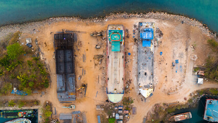 Aerial view of a bustling shipyard with vessels in various stages of construction and repair