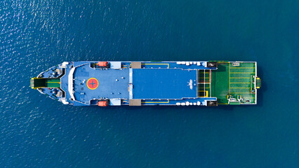 Aerial view of a solitary cargo ship navigating the azure waters, showcasing the scale and isolated beauty of maritime logistics