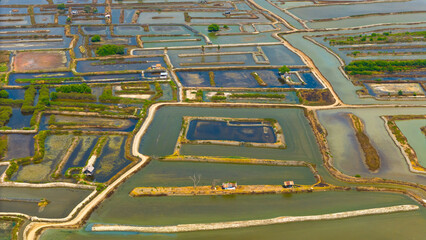 Aerial view showcases the intricate patterns and vibrant hues of salt ponds, revealing nature's palette and human industry's geometry
