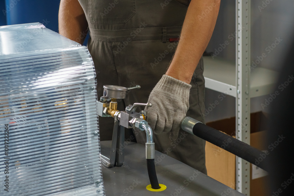 Wall mural a man's hand in a white glove turns on a set with a pressure gauge for testing high pressure hydraul