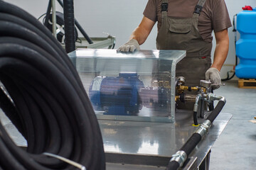 A man's hand in a white glove turns on a set with a pressure gauge for testing high pressure...