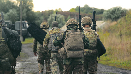 Military Personnel Walking on Rural Road. A group of military men returning after completing a...