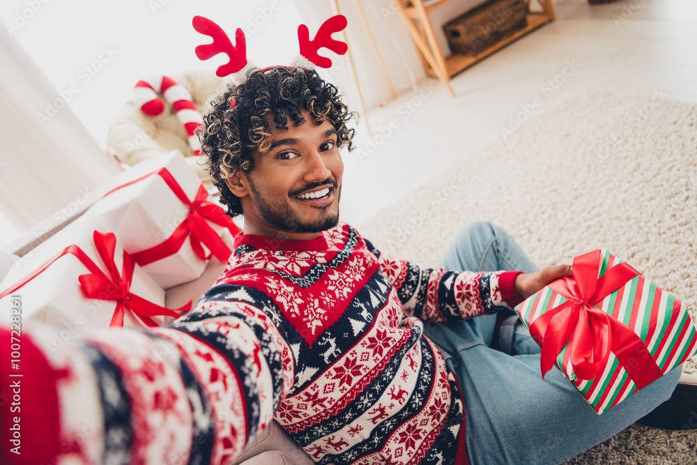 Poster Photo of nice young man make selfie hold gift box wear christmas pullover festive time apartment indoors