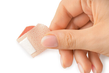 Woman putting medical adhesive bandage on white background, closeup