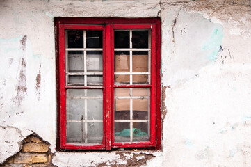 Weathered stucco wall, old facade, grungy abandoned facade of a ruined building. Vintage and lost place background with smashed broken roughcast, plaster and finery. Textured surface lit by sunlight.