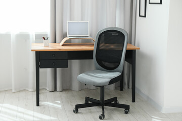 Grey chair, laptop and desk in office