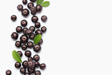 Ripe acai berries and leaves on white background, flat lay. Space for text