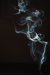 Aroma sticks smoke on black background with white backlit. Burning aromatic incense smoky stick for meditation and relaxing. Incense burning smoke fumes and wisps. Aromatherapy smokes for yoga.