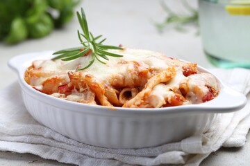 Delicious al forno pasta in baking dish on light table, closeup