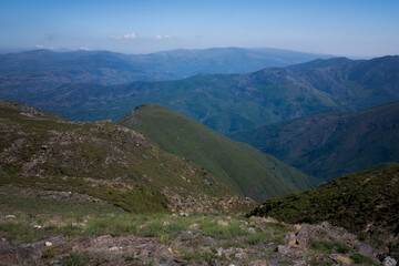 A panoramic view of the mountains in Portugal, showcasing the rugged beauty and vast landscapes under a clear sky.