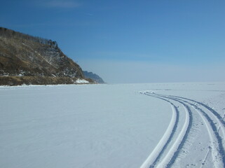 Snow-covered tracks curve across a frozen landscape