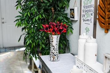 red calla lily flowers in a mirrored metallic mosaic vase
