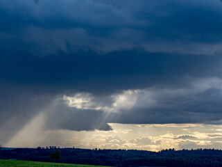 Sonnenstrahlen durchdringen dunklen Wolkenhimmel