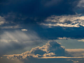 Sonnenstrahlen durchdringen dunklen Wolkenhimmel