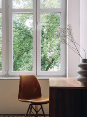 Fototapeta premium Wooden desk and ergonomic chair by a large window in room