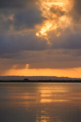 Obraz premium Wonderful view of the setting sun behind gray clouds