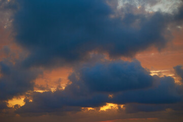 Wonderful view of the setting sun behind gray clouds