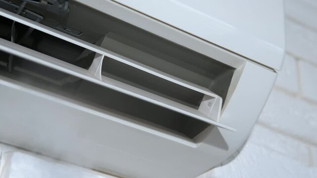 Dusty split system air conditioning on wall. A view of split system working and fresh air comes from the conditioner in the flat.