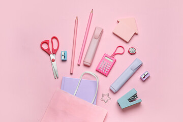 Pencil case with different school stationery on pink background