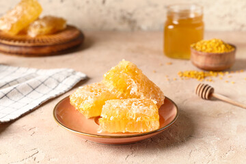 Plate with sweet honeycombs on beige background