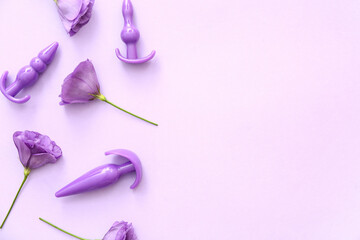 Anal plugs from sex shop and beautiful eustoma flowers on purple background