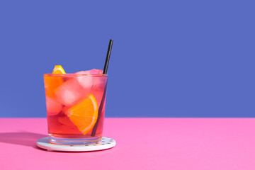 Glass of delicious Negroni cocktail on pink background